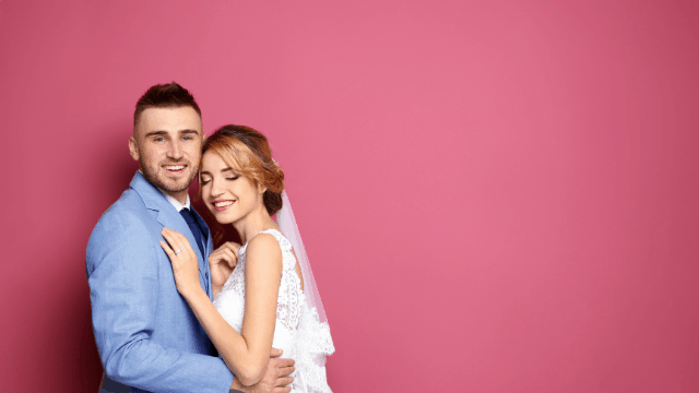 Can't Decide Between 2 Wedding Venues? Here's How To Figure It Out 1 Couple posing against pink background.