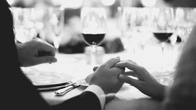 Hosting A Groom's Or Rehearsal Dinner (Quick Guide) 1 Couple holding hands at rehearsal dinner