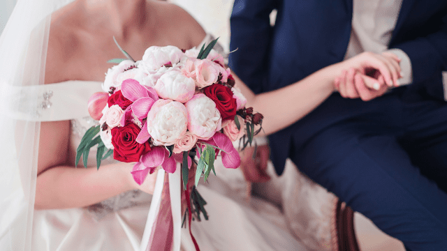 Are Weddings Worth The Cost? 4 Bride holding colorful flower bouquet.