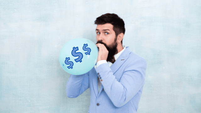 Are Weddings Worth The Cost? 3 Man in a light blue suit inflating a balloon with dollar signs printed on it to represent Are Weddings Worth The Cost