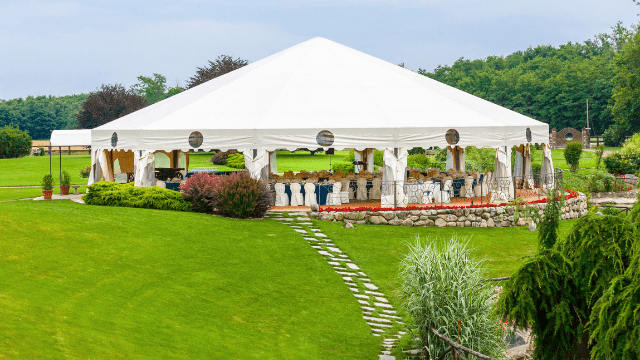 Changing Your Wedding Venue 2 Large white tent set up for wedding banquet on green lawn