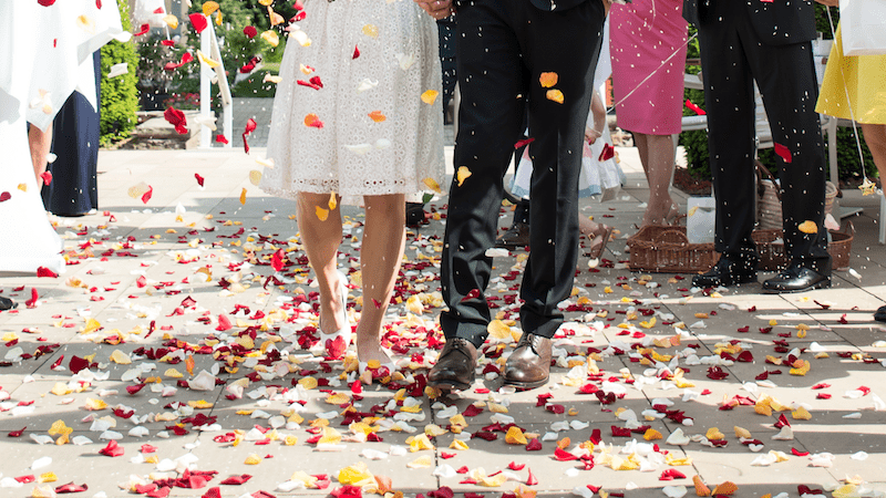 Getting married? Here's How to Avoid Wedding Planning Anxiety! 5 Couple walking through flower petal confetti