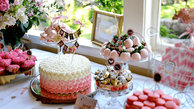 27 Bridal Shower Ideas That Feel Fresh, Fun, and Actually Personal 2 Bridal shower dessert table decorated with pink and white treats, including a rosette cake, chocolate-covered strawberries, cupcakes, and candies