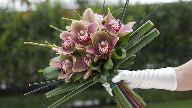 Orchid and Bamboo Bridal Bouquet Modern orchid and bamboo wedding bouquet featuring pink cymbidium orchids and structured green bamboo for a sleek contemporary look