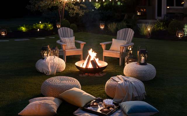 a-backyard-night-wedding-setting backyard night setup with cozy chairs around a fire pit, surrounded by lanterns and pillows for a relaxed evening atmosphere