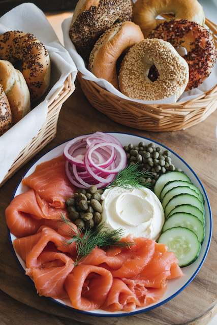 Bagel & Lox Bar Bagel and lox bar with baskets of assorted bagels, smoked salmon, cream cheese, red onion, capers, cucumber, dill