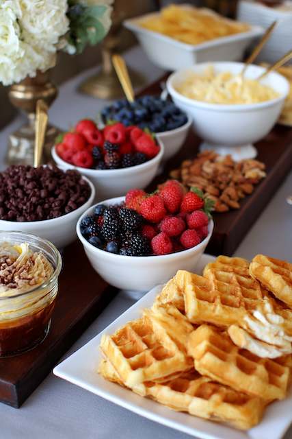 Waffle Bar at brunch wedding reception Waffle bar with fresh berries chocolate chips nuts and whipped butter at a brunch wedding reception