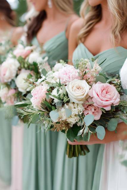 Sage Green & Blush Pink Bridal Party Bridesmaids in sage green dresses holding lush bouquets of blush and ivory roses, white hydrangeas, and eucalyptus leaves for a soft, romantic look