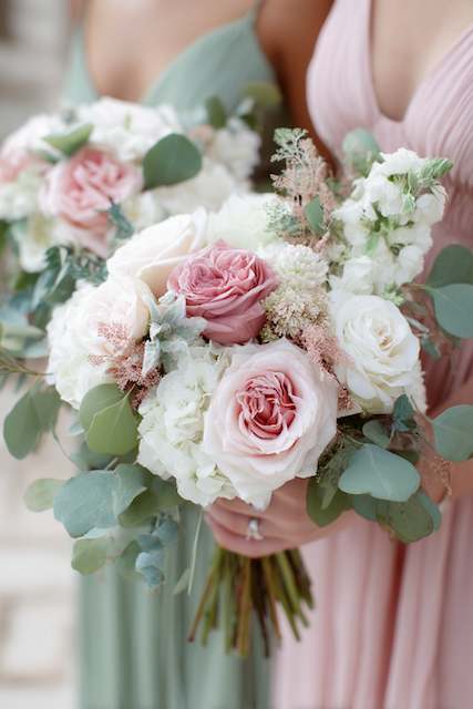 Blush and white rose bouquet with eucalyptus and hydrangeas held by a bridesmaid in a blush dress Blush and white rose bouquet with eucalyptus and hydrangeas held by a bridesmaid in a blush dress