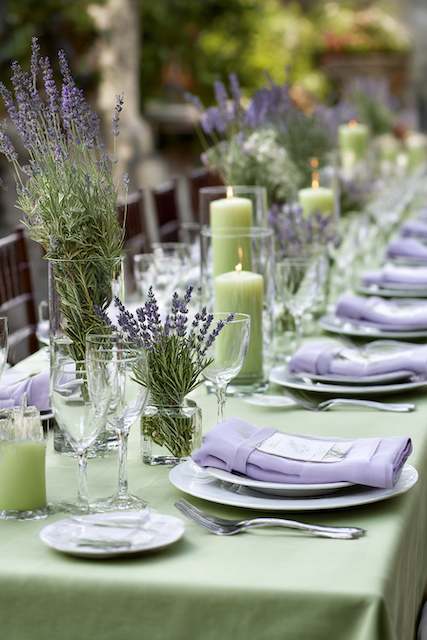 Sage Green & Lavender Elegant sage green and lavender wedding table setting featuring lilac napkins, lavender floral centerpieces, and green pillar candles in glass holders for a soft, romantic atmosphere
