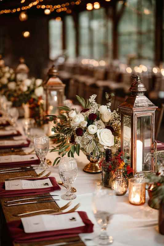candles, fairy lights, and vintage lanterns centerpieces. Elegant country-themed wedding reception with floral centerpieces, vintage lanterns, and romantic candlelight