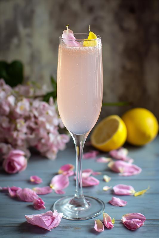 champagne flute with Blush Gin Fizz with gin, elderflower, lemon, soda, and rose petal garnish—light and floral for spring weddings