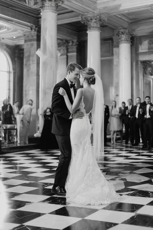 Old Money Wedding Aesthetic: Your Complete Style Guide 19 Black and white photo of bride and groom sharing their first dance in a grand ballroom with marble columns