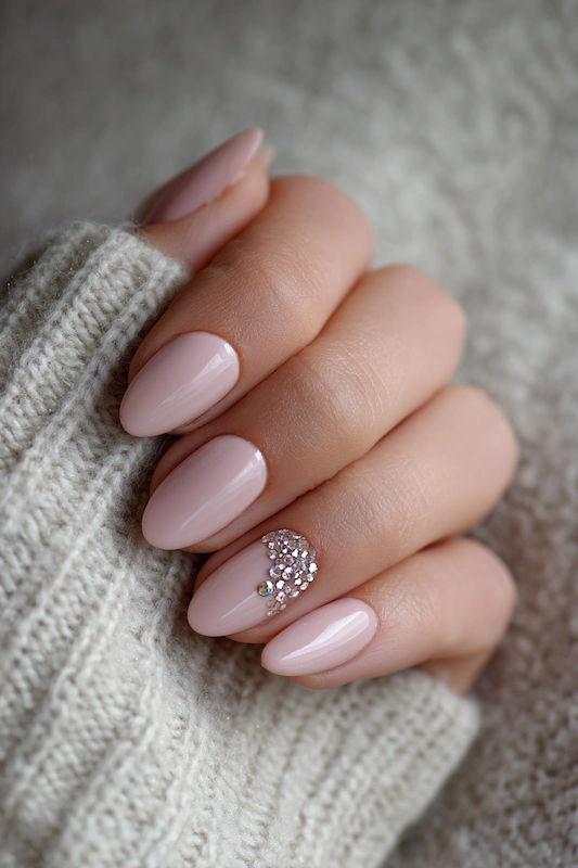 Close up of bride hand with blush pink almond nails glossy finish and rhinestone accent on ring finger soft knit backdrop