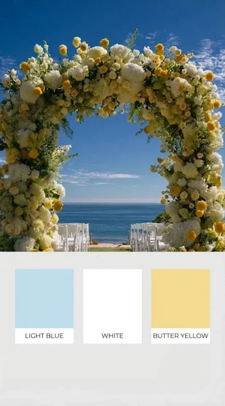 25 Pastel Wedding Theme Ideas That Look Modern and Fresh 3 Light blue white and butter yellow floral wedding arch framing an ocean view ceremony aisle with white chairs on grass