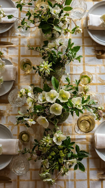 35 Spring Wedding Centerpieces With Flower Pairings Brides Can Actually Use 10 Overhead wedding table with white florals and greenery centerpieces, gold grid linen, layered plates, glassware, and refined styling