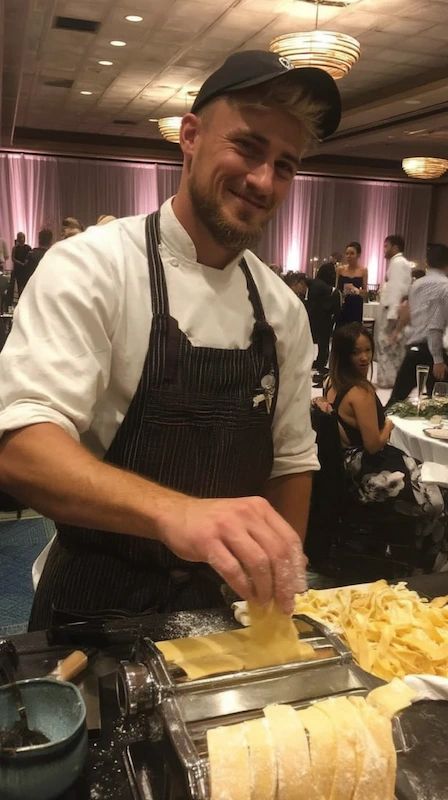 25 Wedding Pasta Bar Ideas Your Guests Will Obsess Over 3 Chef preparing fresh pasta at a live wedding station, smiling while rolling dough as guests watch in elegant ballroom