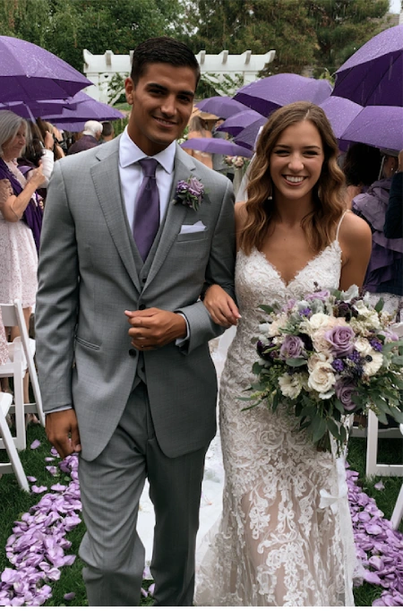 What to discuss before planning a wedding 5 Bride and groom walk down the aisle with lavender bouquet as guests hold purple umbrellas during outdoor wedding