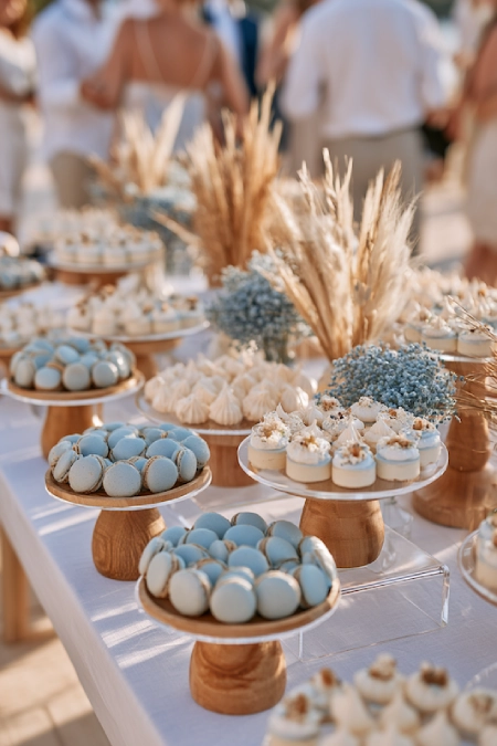 Dusty Blue Wedding Decor: Florals, Table Settings and Reception Styling 9 Dusty blue wedding dessert table with macarons, mini desserts, dried pampas grass, and elegant outdoor reception styling.