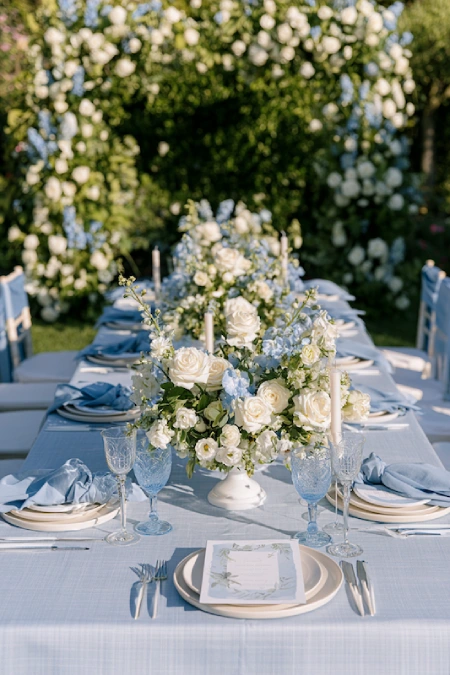 Dusty Blue Wedding Decor: Florals, Table Settings and Reception Styling 19 Garden wedding reception with dusty blue and ivory floral centerpieces, soft blue linens, and romantic outdoor tablescape.