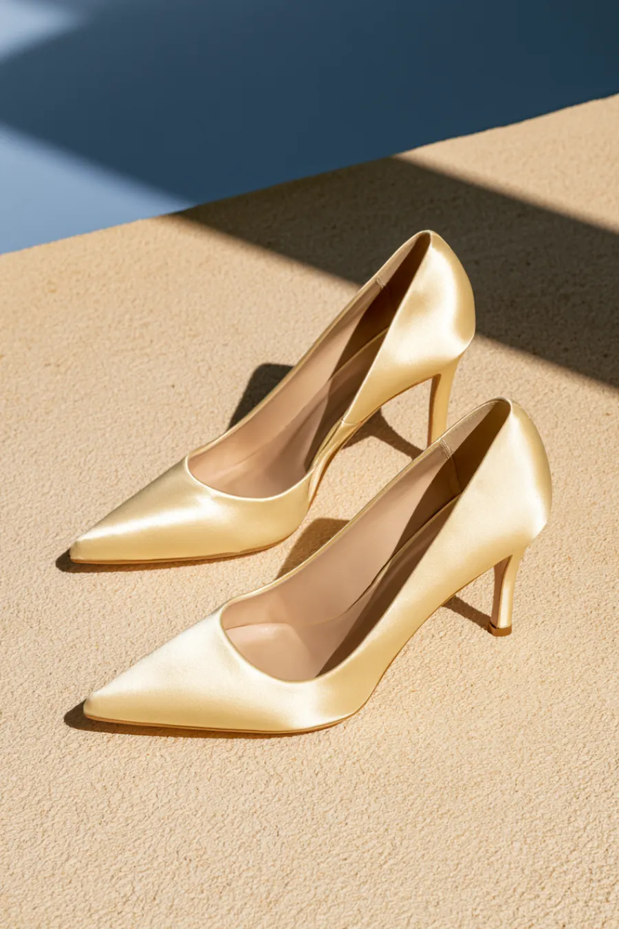 Wedding Shoes for the Bride: 27 Beautiful Ideas That Balance Style and Comfort 24 Classic ivory satin wedding pumps with pointed toes and mid-height heels in warm sunlight for timeless bridal elegance