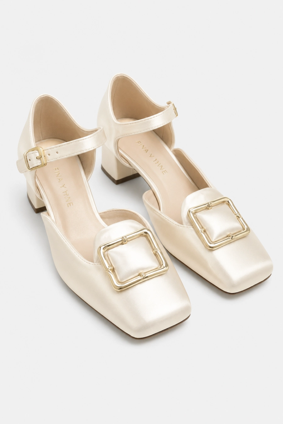 Wedding Shoes for the Bride: 27 Beautiful Ideas That Balance Style and Comfort 11 Ivory satin bridal Mary Jane heels with square toes, gold buckle accents, ankle straps, and block heels on white background