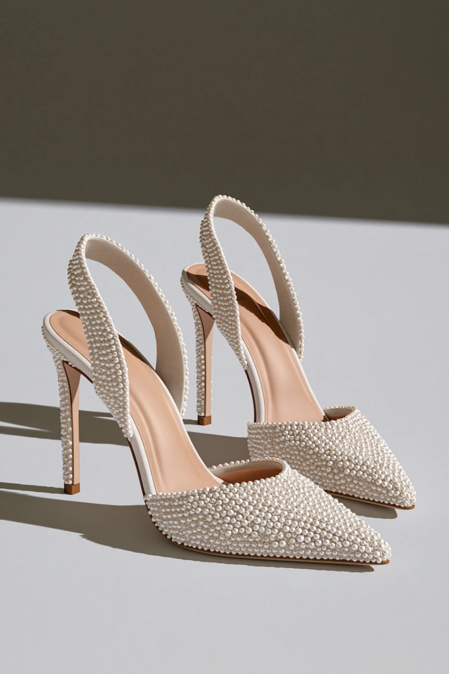 Wedding Shoes for the Bride: 27 Beautiful Ideas That Balance Style and Comfort 6 Pearl embellished slingback bridal heels with pointed toes and slim stilettos in a luxury studio product photography setting
