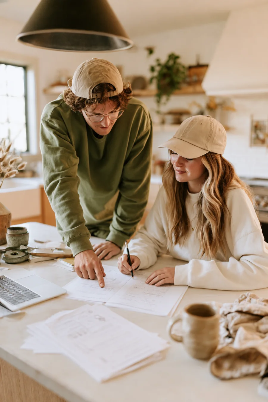 6-Month Wedding Planning Timeline - How to Plan a Wedding in 6 Months 1 Gen Z couple reviewing wedding planning documents together at a kitchen table, with a laptop, notes and a pencil in view